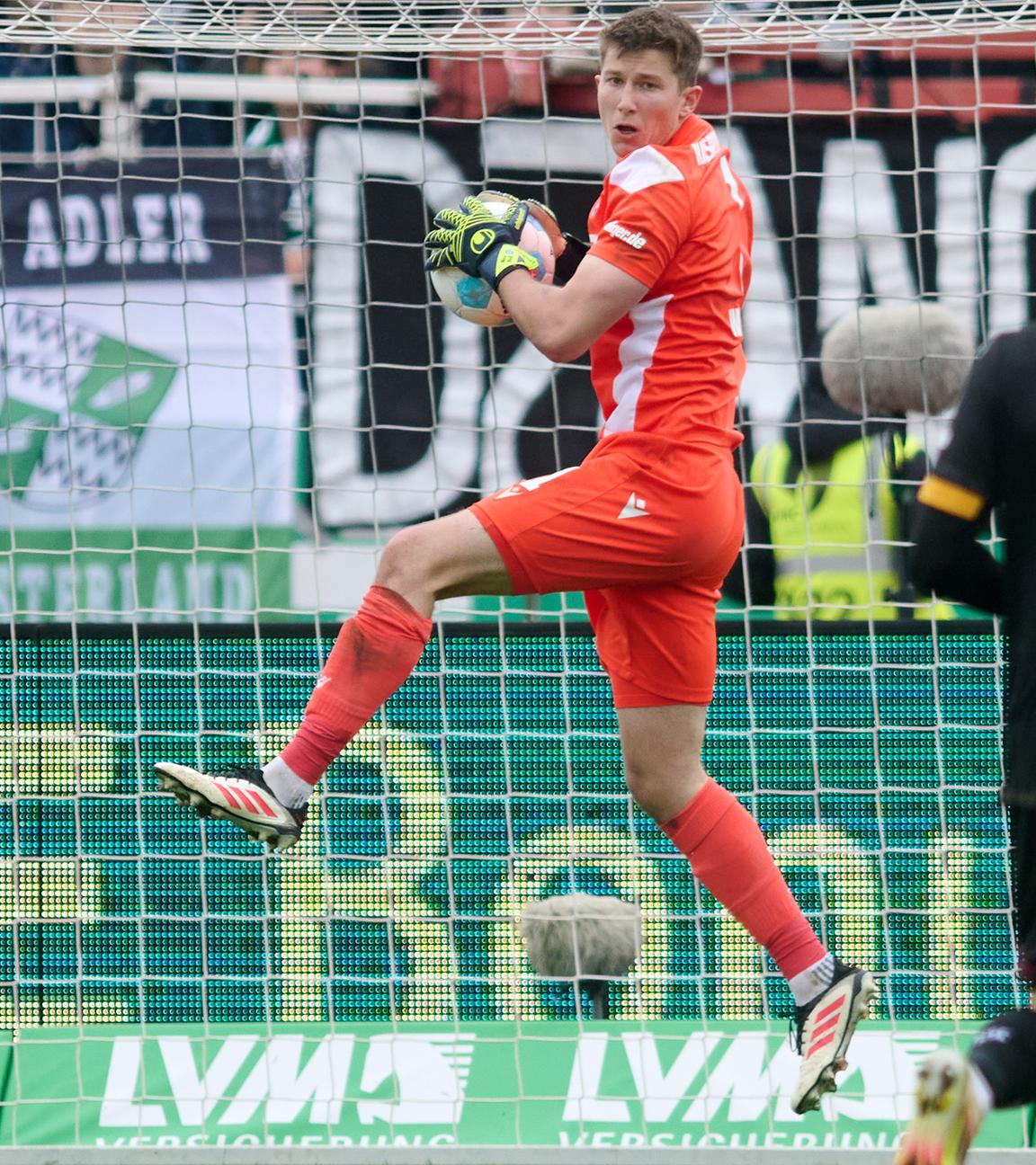 Fußball: 2. Bundesliga, Preußen Münster - Karlsruher SC: Karlsruhes Torwart Max Weiß fängt im Sprung einen Ball.