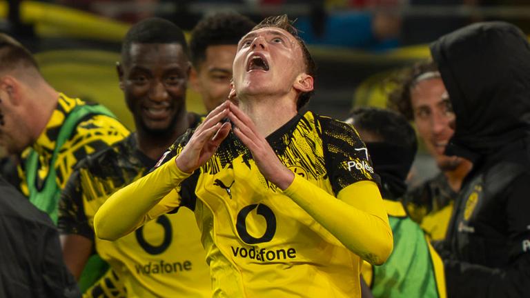 Maximilian Beier (Borussia Dortmund) schaut nach oben, während hinter ihm über den Sieg gegen Köln gejubelt wird.