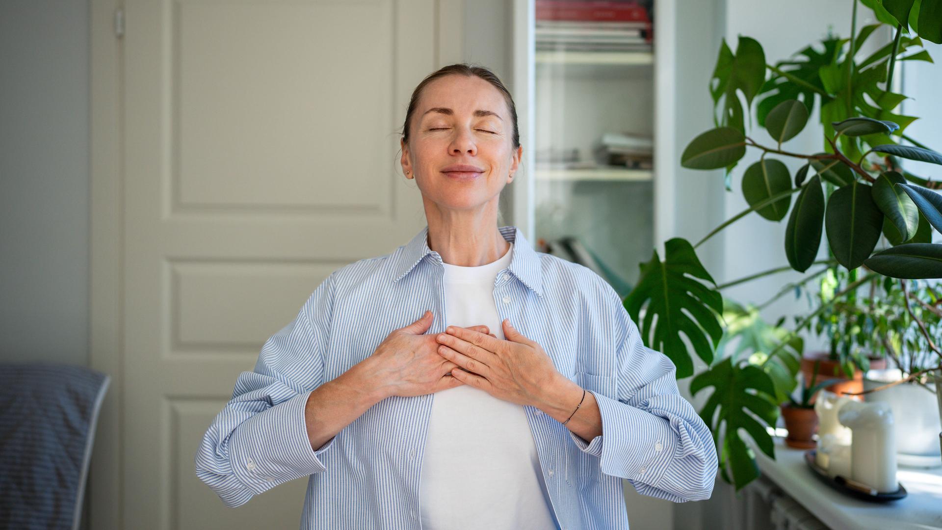 Eine Frau schließt die Augen und hält für einen Moment inne.