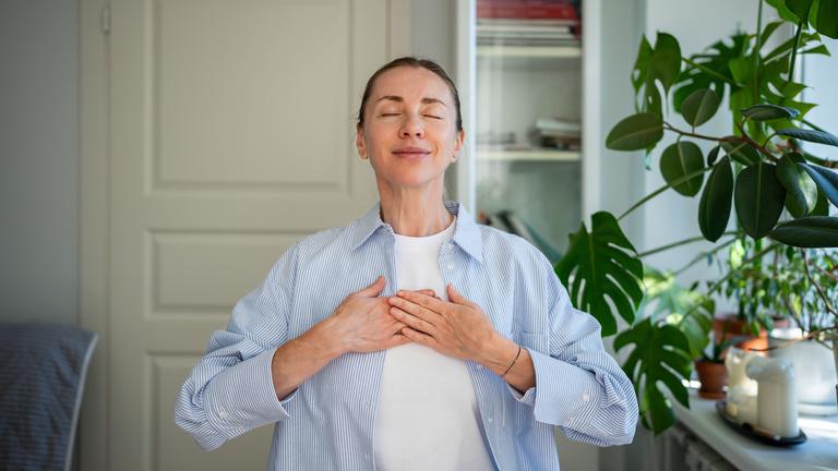 Eine Frau schließt die Augen und hält für einen Moment inne.