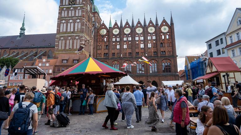 Mecklenburg-Vorpommern, Stralsund: Touristen besuchen den historischen Markt der Wallensteintage vor dem Rathaus von Stralsund.