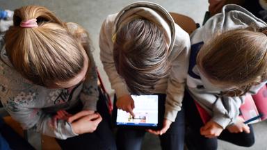 Schüler arbeiten mit einem Tablet.