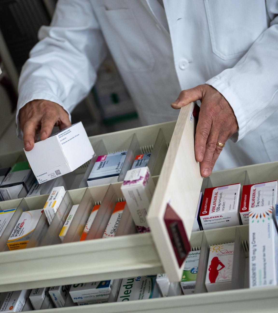 Apotheker nimmt Medikamentenverpackung aus Schublade