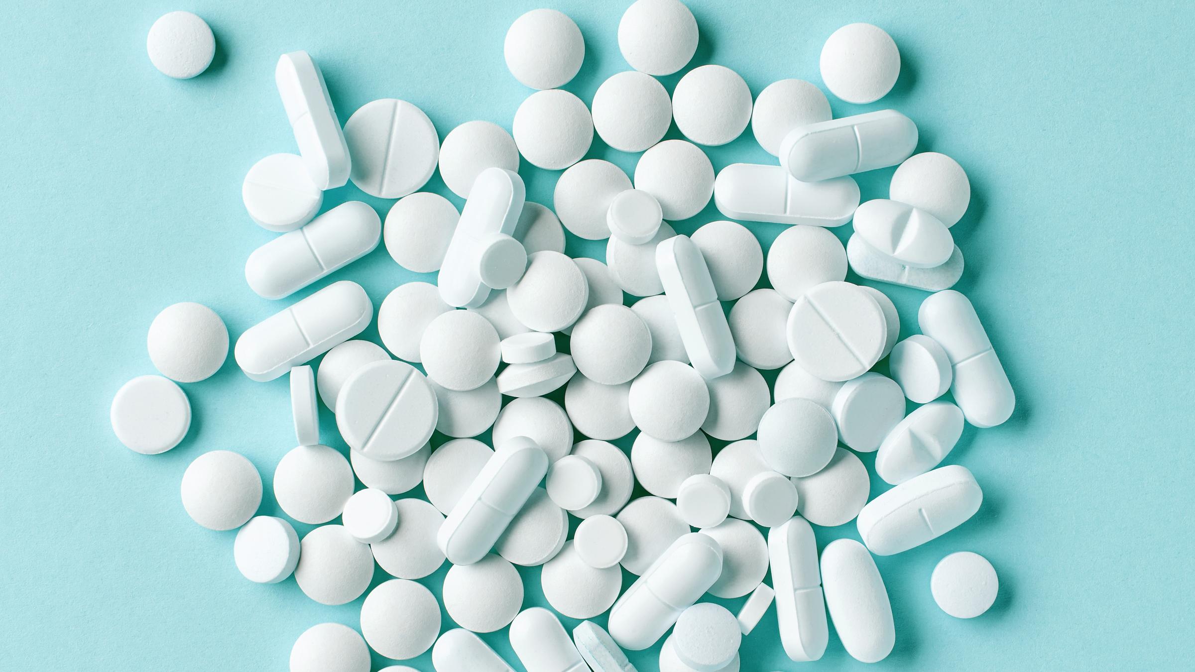 Diverse weiße Tabletten auf blauem Hintergrund