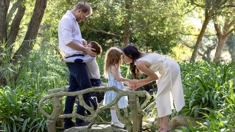 Meghan Markle und Prinz harry mit ihren beiden Kidnern im Wald.