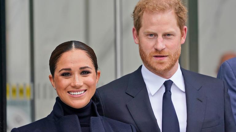 Meghan Markle und Prinz Harry stehen in schwarzer Kleidug nebeneinander.