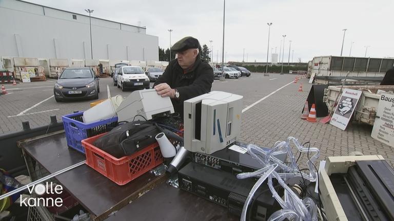 Ein Mann betrachtet den Elektroschrott vor sich.