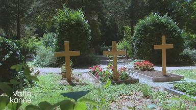 Drei Gräber nebeneinander auf einem Friedhof.