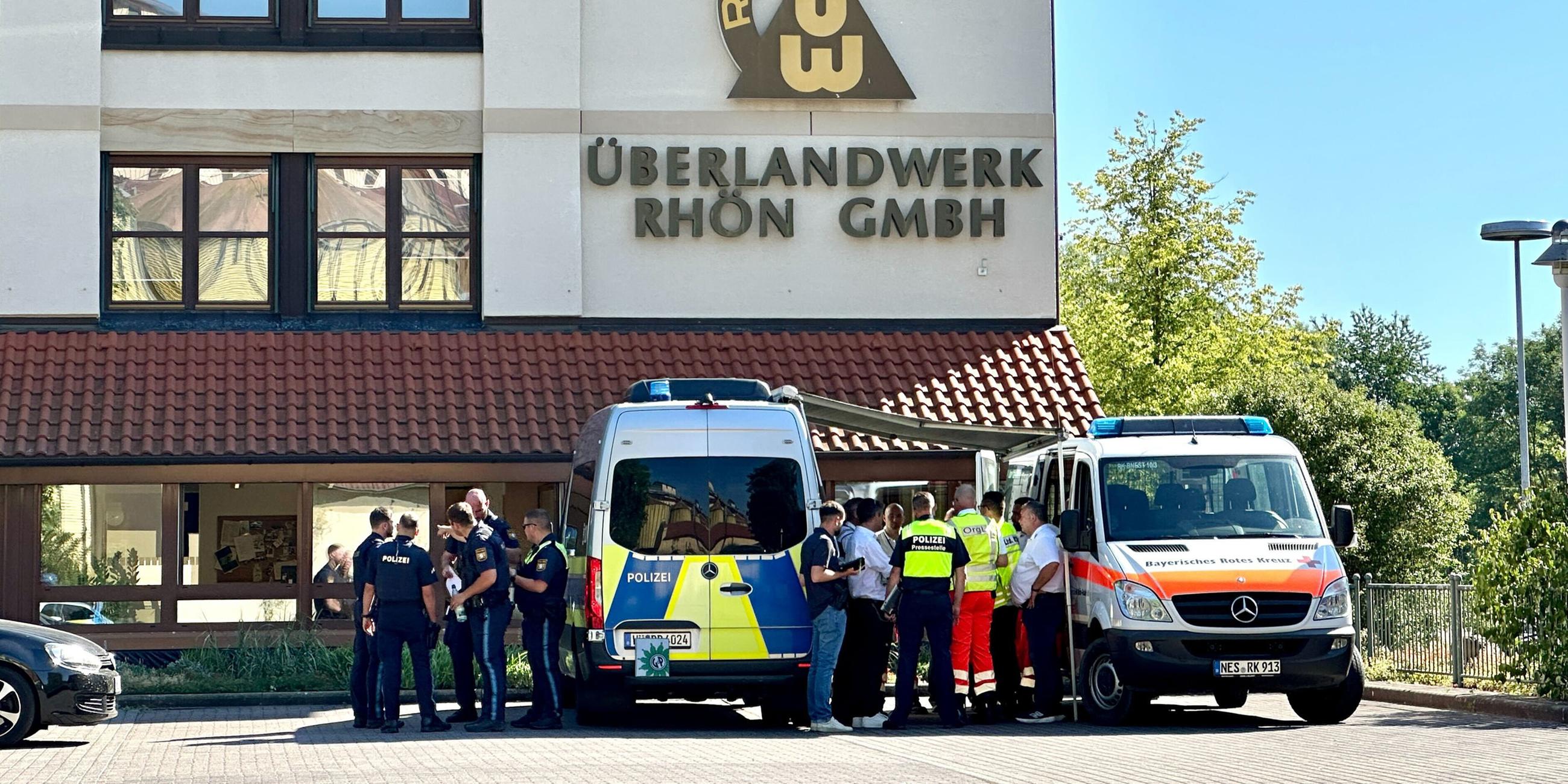 Polizei und Rettungskräfte stehen auf dem Gelände des regionalen Netzbetreibers Überlandwerk Rhön. Ein 21-Jähriger hat am 01.06.2025 in der Firma einen Kollegen getötet und zwei weitere schwer verletzt.
