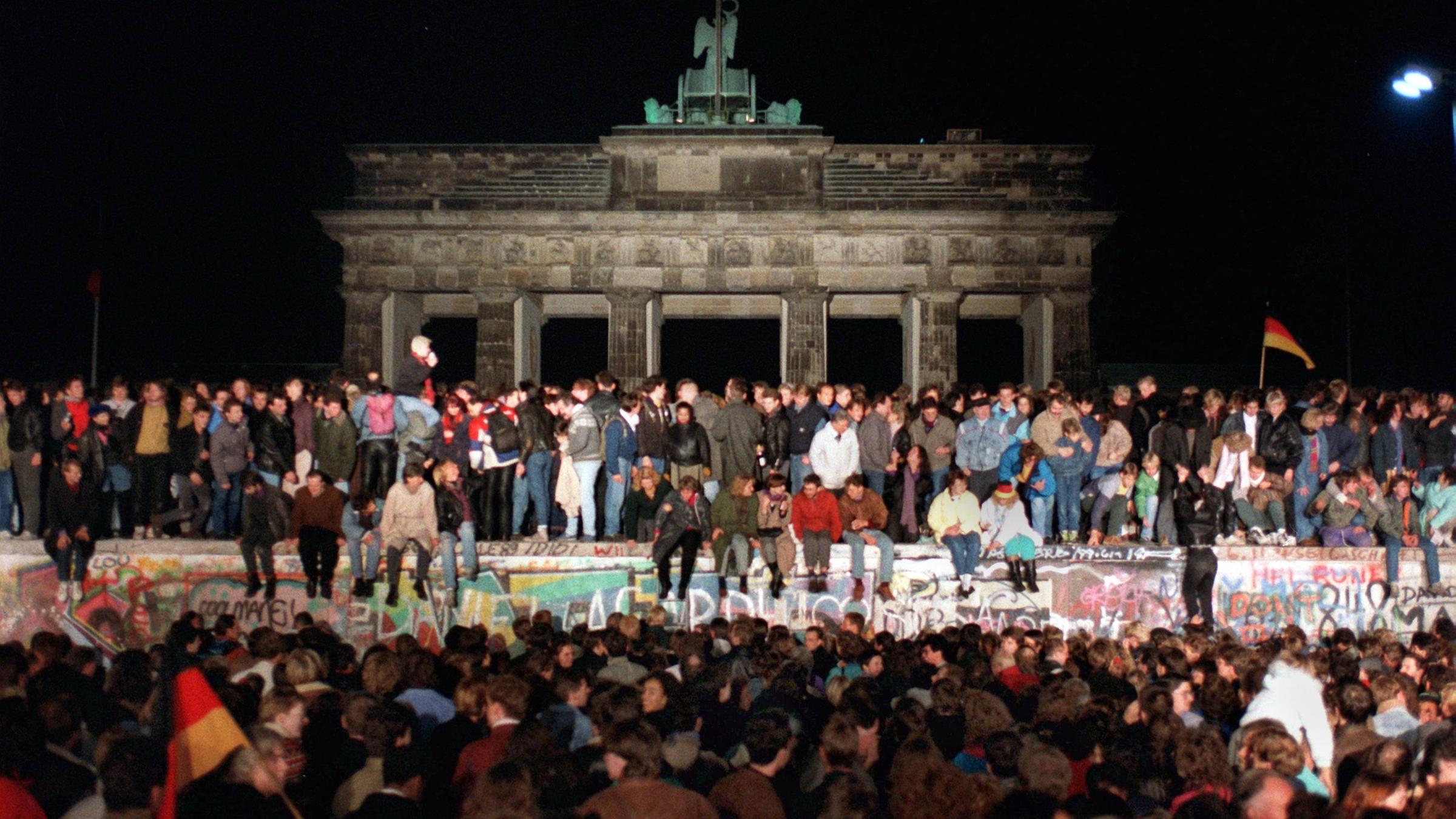 Menschen feiern den Mauerfall vor dem Brandenburger Tor in Berlin 1989