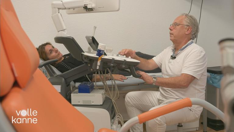 Frau auf Liege Arzt schaut auf Bildschirm