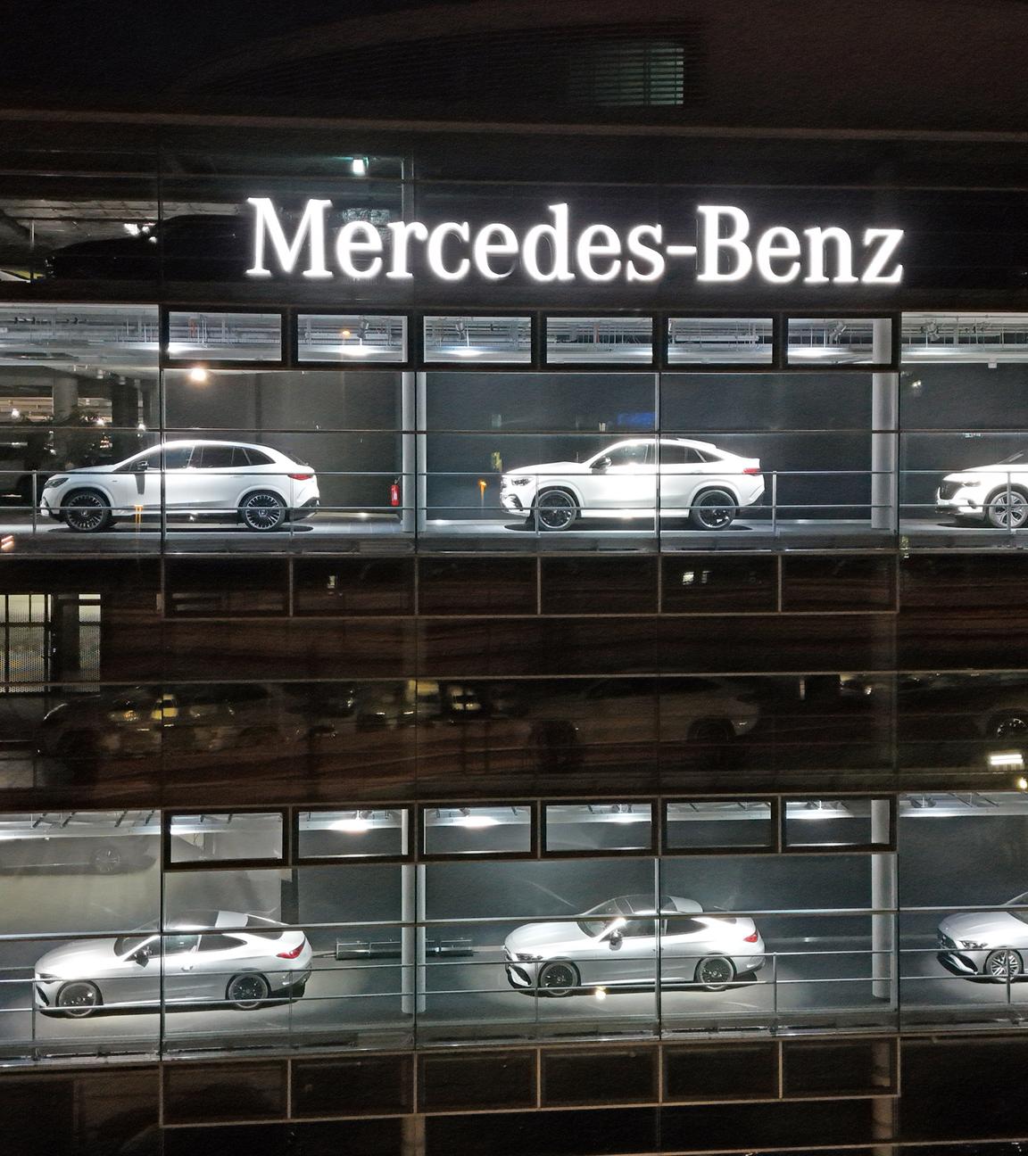 Das beleuchtete Mercedes Benz Autohaus in München ist zu sehen.