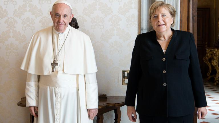 Angela Merkel steht neben Papst Franziskus.