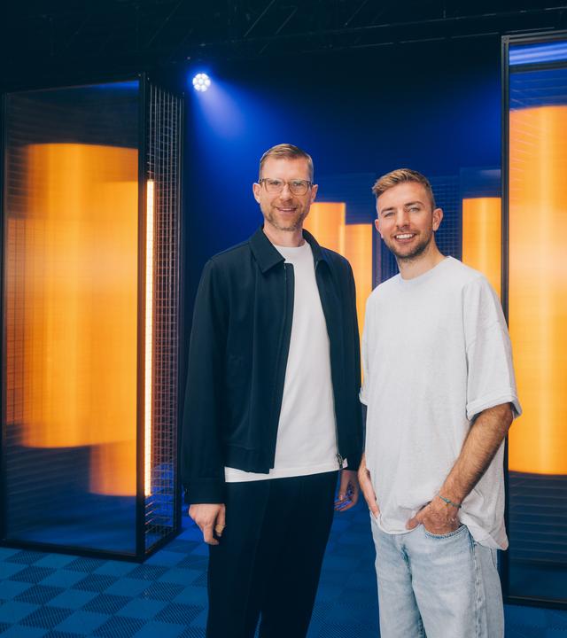 Per Mertesacker und Christoph Kramer stehen nebeneinander und blicken in die Kamera.