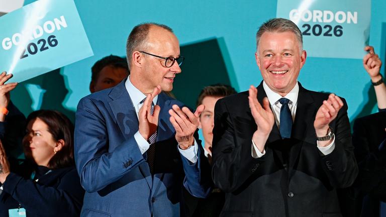 Bundeskanzler Friedrich Merz (l, CDU) und Gordon Schnieder, CDU-Spitzenkandidat bei der Landtagswahl in Rheinland-Pfalz, unterhalten sich in der Salierhalle