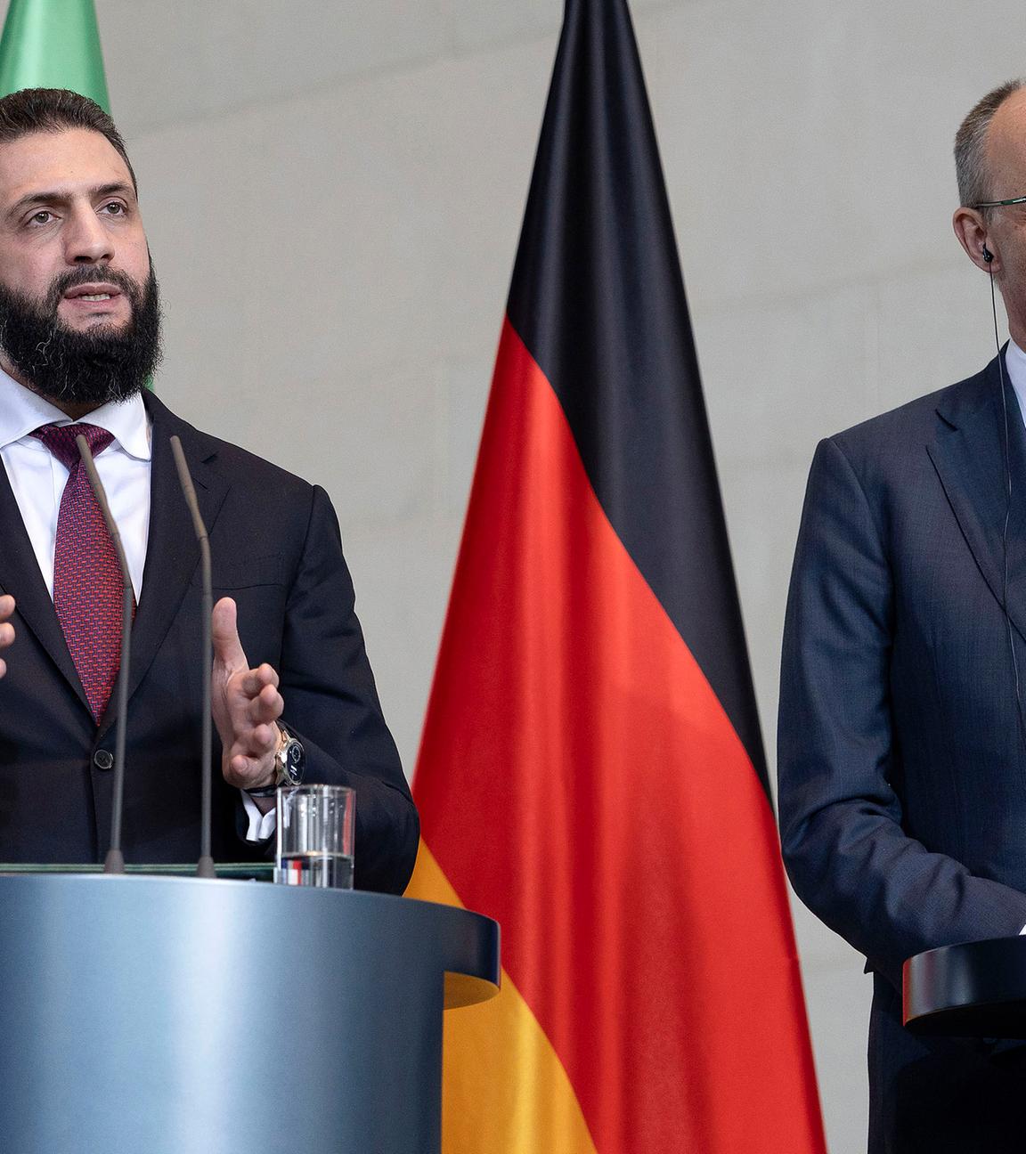 Syriens Übergangspräsident Ahmed al-Scharaa und Bundeskanzler Friedrich Merz stehen am Rednerpult bei der gemeinsamen Pressekonferenz im Bundeskanzleramt, aufgenommen am 30.03.2026