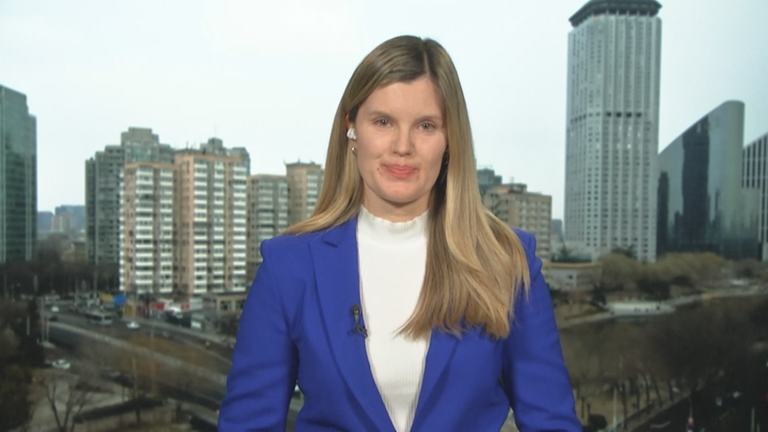 ZDF-Korrespondentin Elisabeth Schmidt in China vor einer Stadt bei Tag.