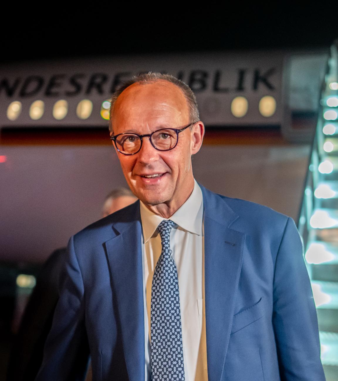 Merz nachts vor dem Flugzeug der Bundesrepublik Deutschland