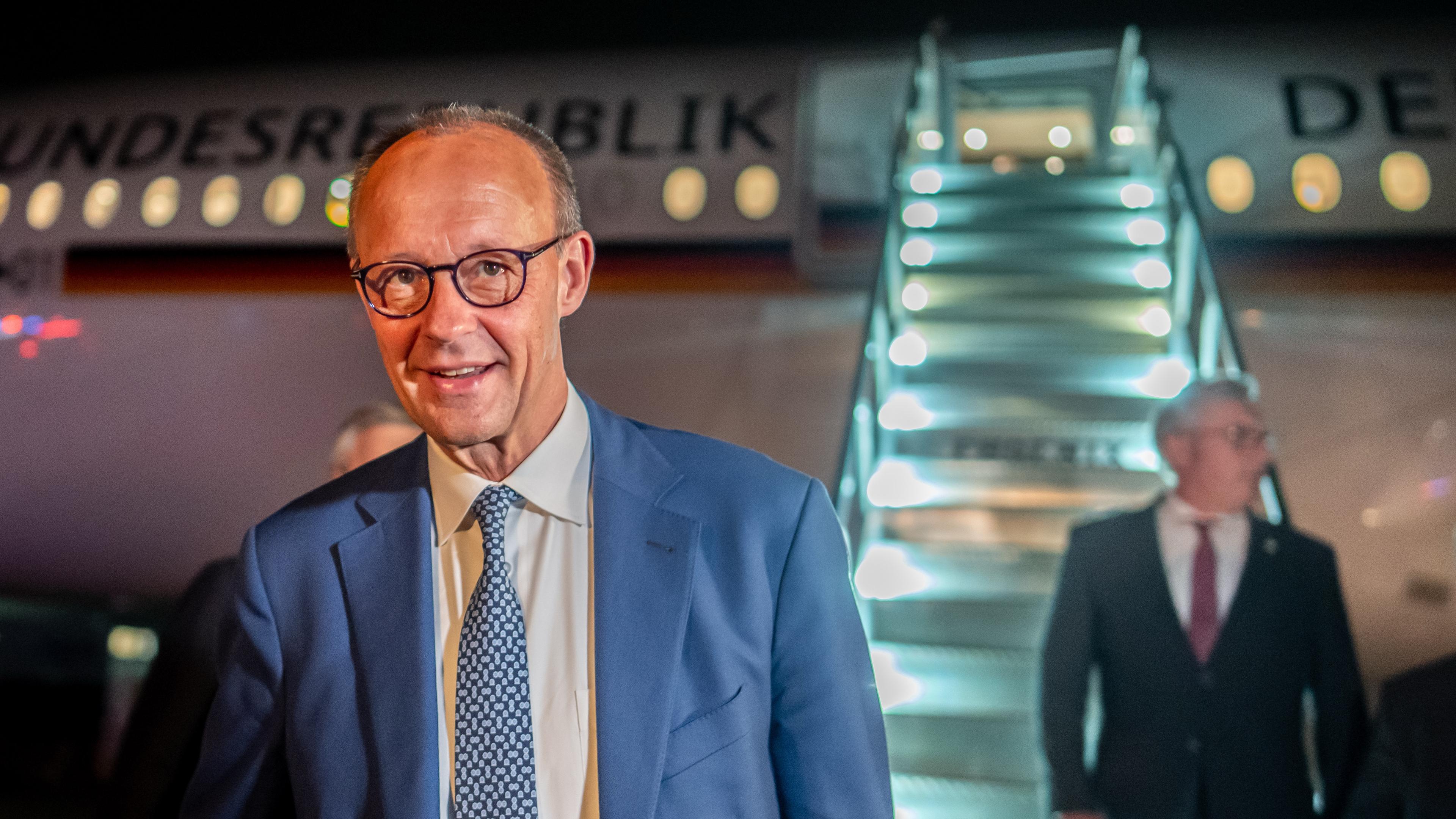 Merz nachts vor dem Flugzeug der Bundesrepublik Deutschland
