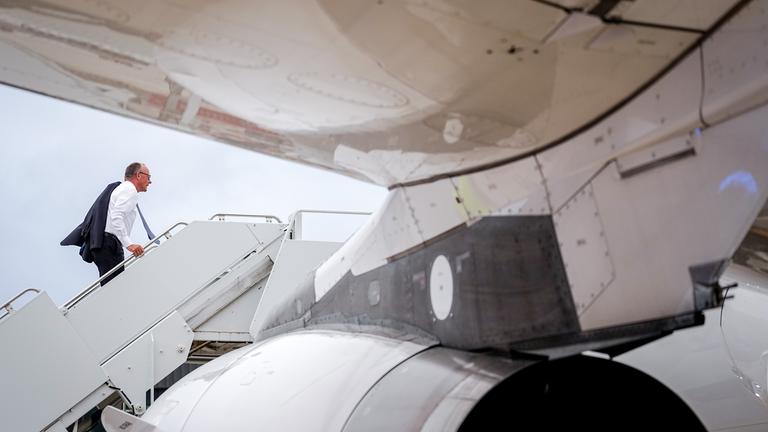 18.08.2025, USA, Washington: Bundeskanzler Friedrich Merz (CDU) geht nach dem Treffen mit US-Präsident Trump und dem ukrainischen Präsident Selenskyj für den Rückflug nach München die Gangway zum Airbus A319 der Luftwaffe hinauf.