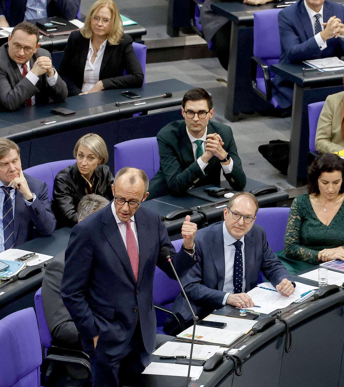 Friedrich Merz redet im Bundestag, die AfD-Fraktion im Hintergrund.