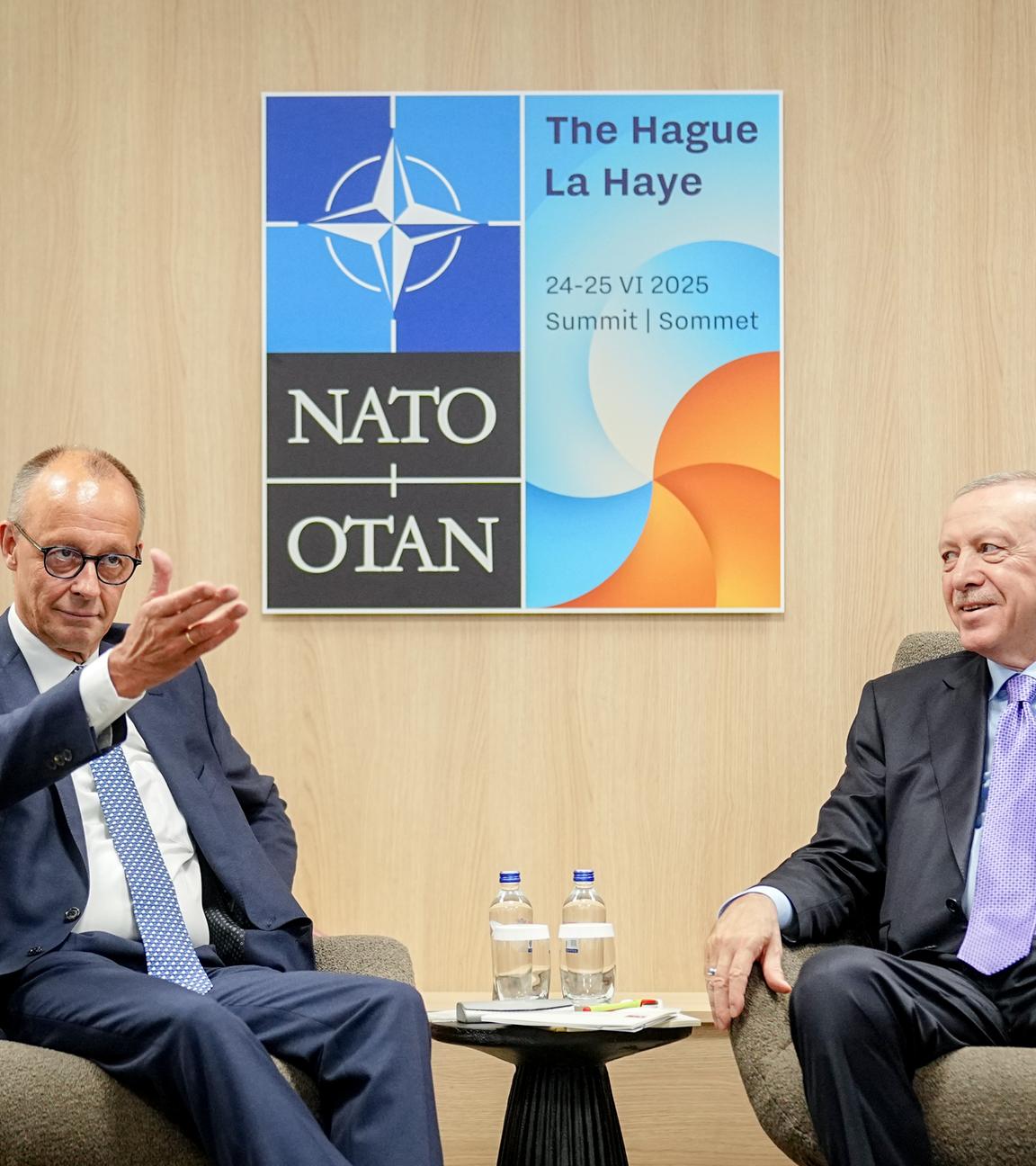 Merz und Erdogan sitzen nebeneinander