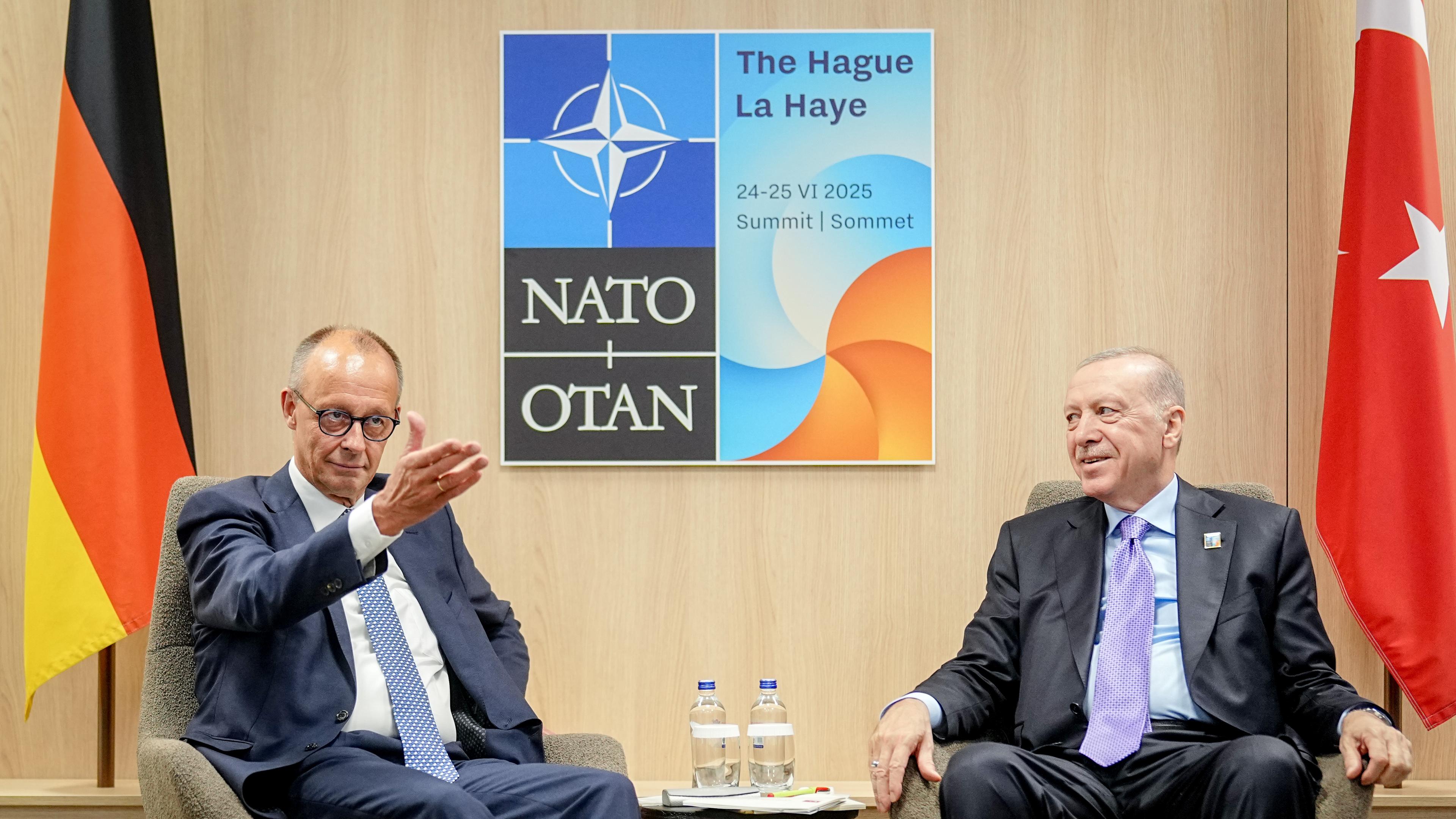 Merz und Erdogan sitzen nebeneinander