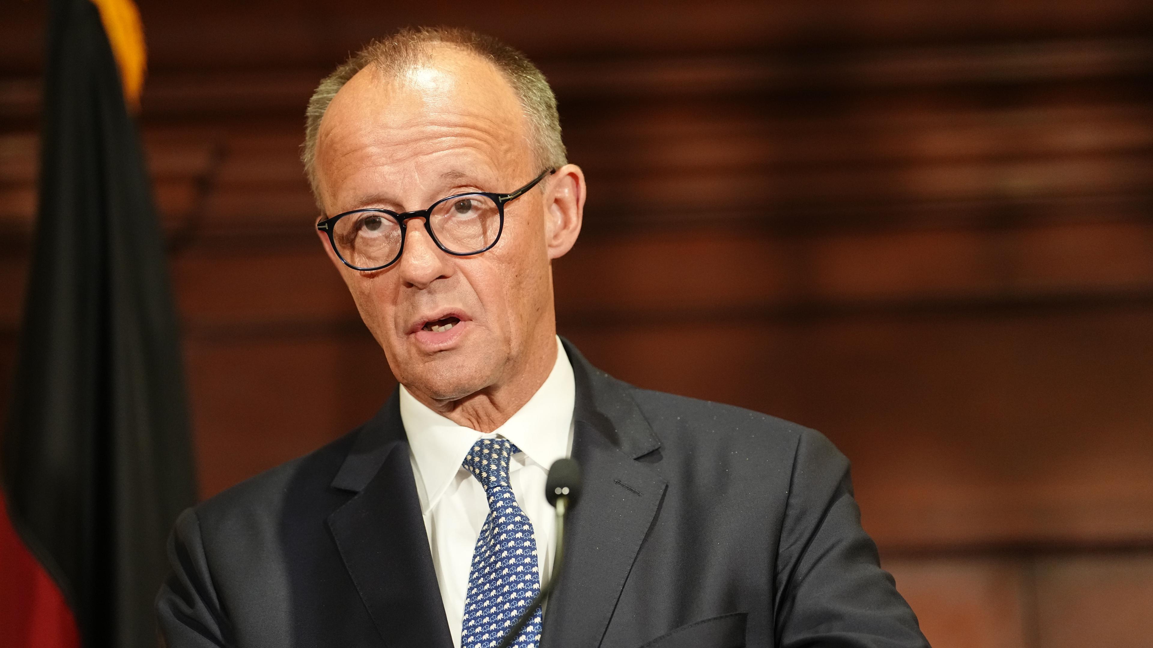 Bundeskanzler Merz vor einem Podest