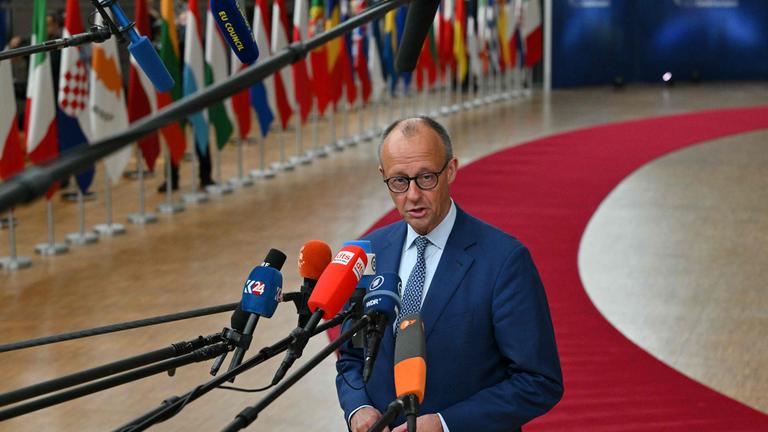 Merz spricht zu Presse, Mikrofone werden ihm entgegengestreckt