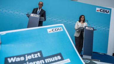 Bundeskanzler Friedrich Merz (CDU) neben CDU-Generalsekretärin Franziska Hoppermann bei der Pressekonferenz nach der Sondersitzung des Parteipräsidiums mit Klausurtagung. Vorne ein Flyer "Was jetzt passieren muss".