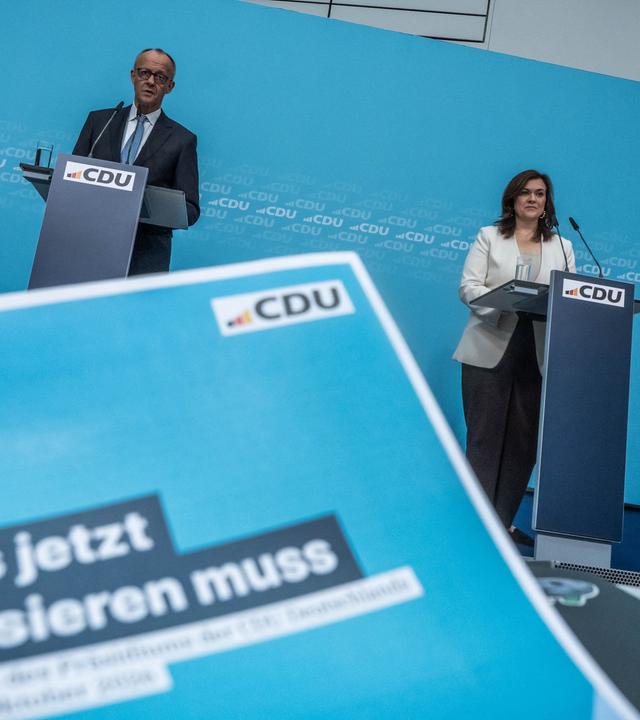 Bundeskanzler Friedrich Merz (CDU) neben CDU-Generalsekretärin Franziska Hoppermann bei der Pressekonferenz nach der Sondersitzung des Parteipräsidiums mit Klausurtagung. Vorne ein Flyer "Was jetzt passieren muss".