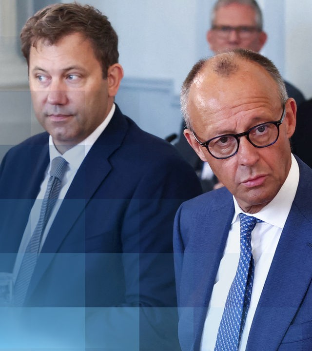 Friedrich Merz, Lars Klingbeil und Alexander Dobrindt sitzen beim gemeinsamen Foto vor der Kabinettsklausur nebeneinander und schauen in die Kameras.