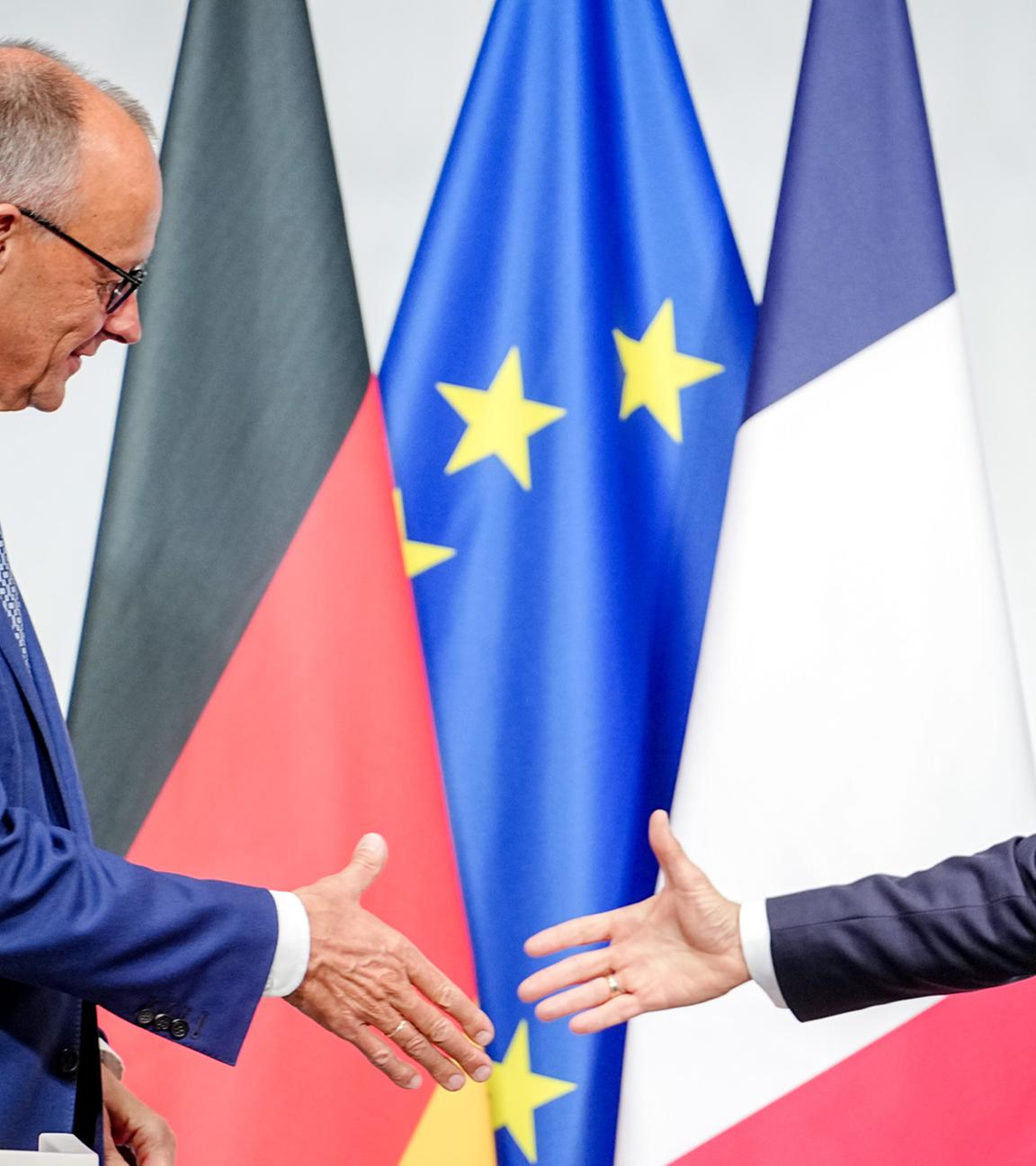  Bundeskanzler Friedrich Merz (CDU, l) und Frankreichs Präsident Emmanuel Macron reichen sich beim deutsch-französischen Regierungstreffen zur Wirtschafts- und Sicherheitspolitik nach der Pressekonferenz die Hände.