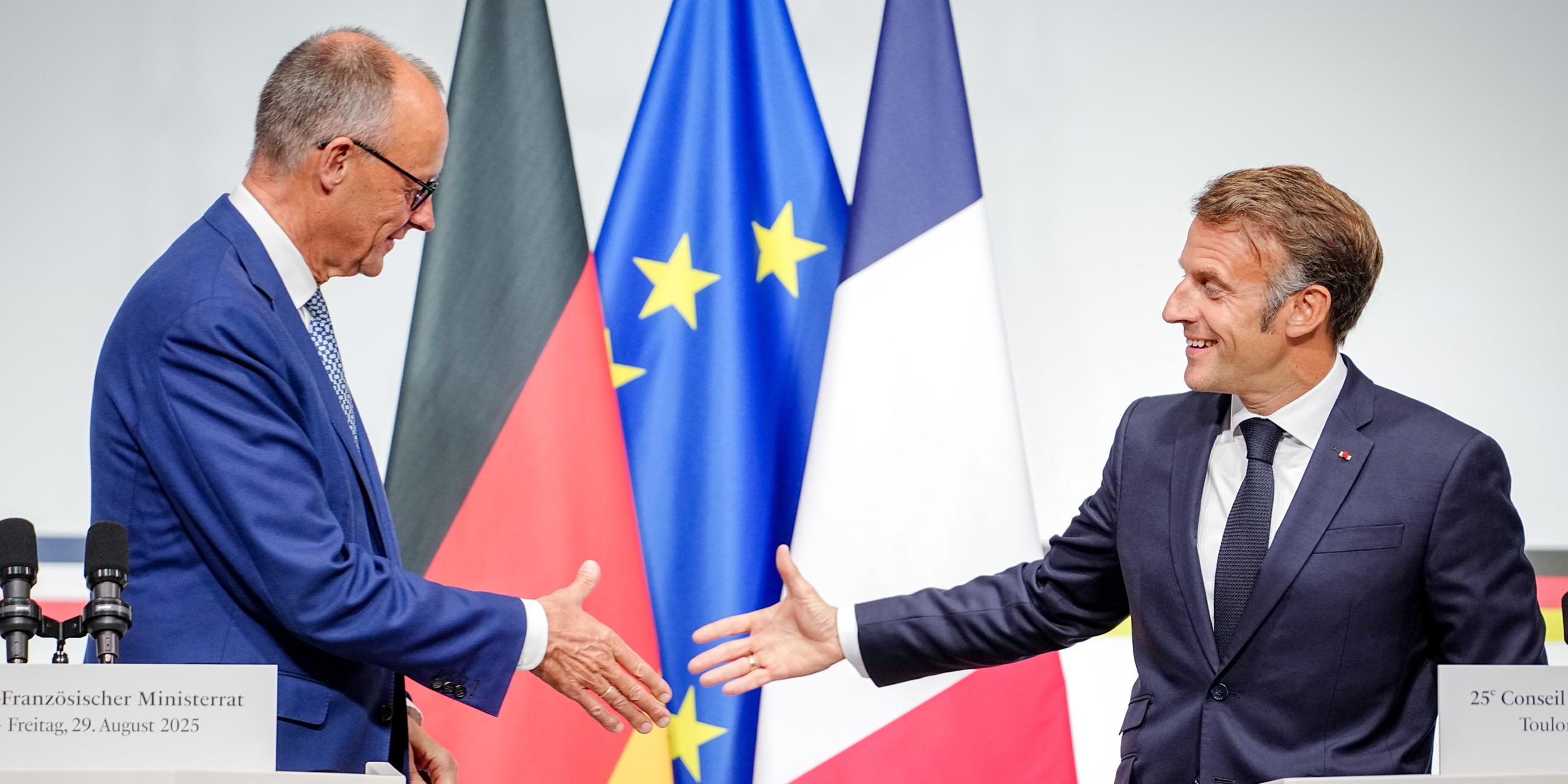  Bundeskanzler Friedrich Merz (CDU, l) und Frankreichs Präsident Emmanuel Macron reichen sich beim deutsch-französischen Regierungstreffen zur Wirtschafts- und Sicherheitspolitik nach der Pressekonferenz die Hände.