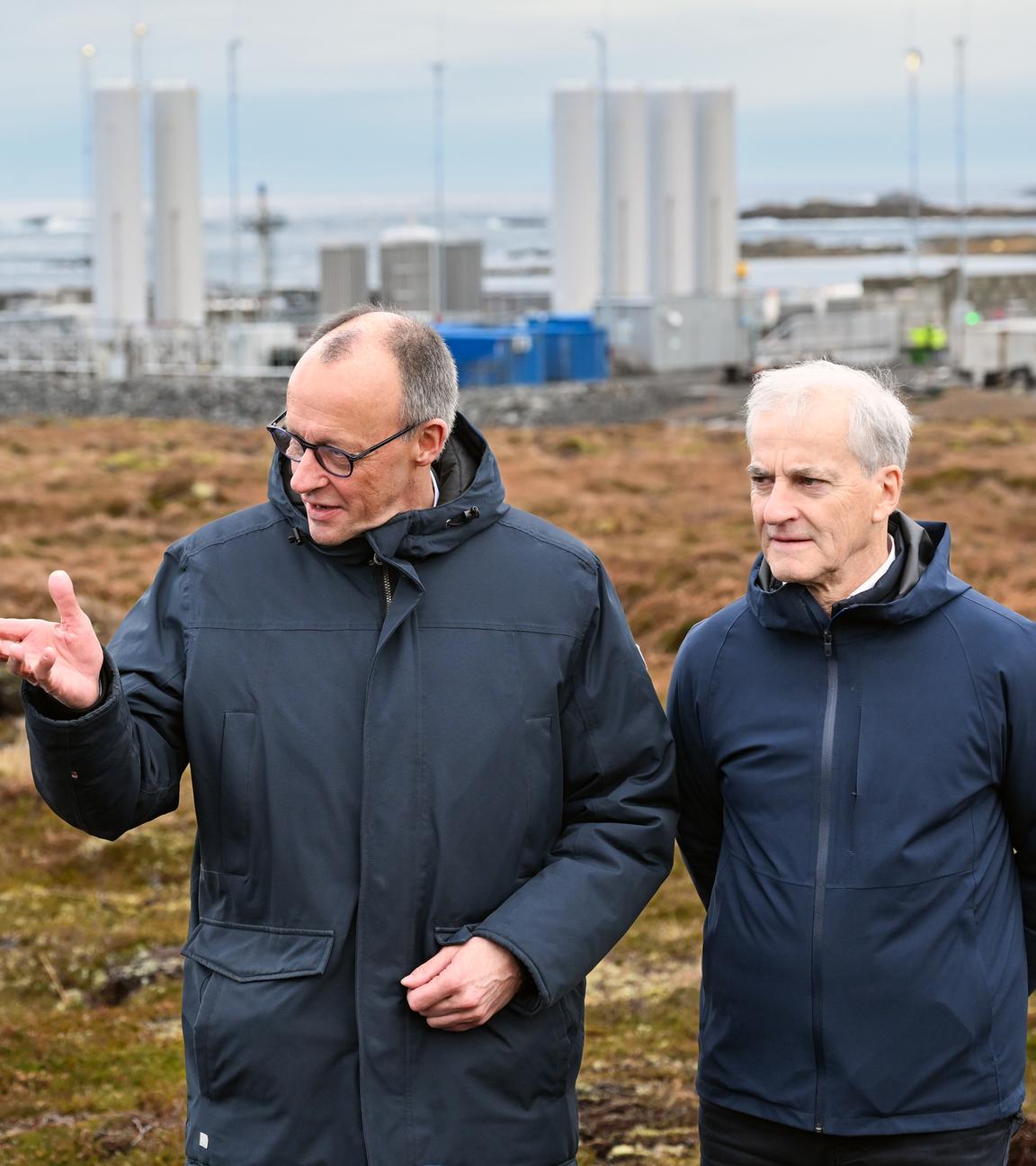 Bundeskanzler Friedrich Merz (l, CDU) und Jonas Gahr Støre, Ministerpräsident von Norwegen, unterhalten sich vor der Kulisse der Raketenstartrampe