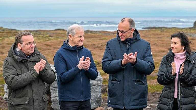 Boris Pistorius (l-r, SPD), Jonas Gahr Støre,Friedrich Merz (CDU) und Dorothee Bär (CSU) stehen auf einer Wiese nahe der Raketenstartrampe 