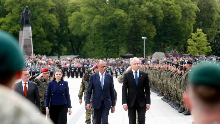 Bundesverteidigungsminister Boris Pistorius, die litauische Verteidigungsministerin Dovile Sakaliene, Bundeskanzler Friedrich Merz und der litauische Staatspräsident Gitanas Nauseda nehmen am 22. Mai 2025 auf dem Domplatz in Vilnius, Litauen, an der Einweihung der 45. deutschen Panzerbrigade „Litauen“ teil.