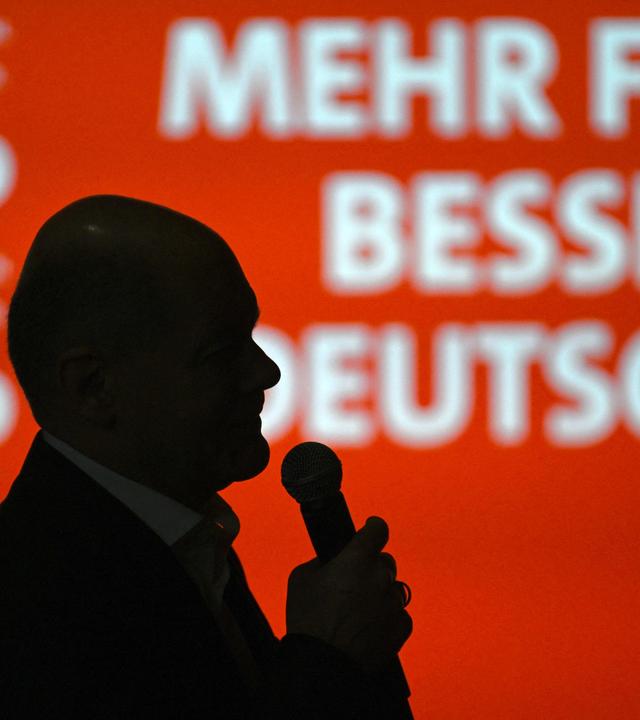Olaf Scholz, Spitzenkandidat der Sozialdemokratischen Partei (SPD) für das Amt des Bundeskanzlers, spricht am 22. Februar 2025, einen Tag vor der Bundestagswahl am 23. Februar, in seinem Wahlkreis Potsdam südwestlich der deutschen Hauptstadt vor dem Hintergrund des SPD-Logos zu den Bürgern.