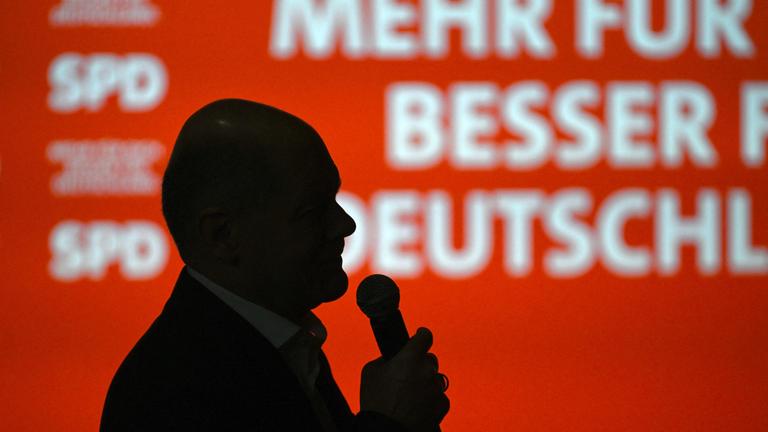 Olaf Scholz, Spitzenkandidat der Sozialdemokratischen Partei (SPD) für das Amt des Bundeskanzlers, spricht am 22. Februar 2025, einen Tag vor der Bundestagswahl am 23. Februar, in seinem Wahlkreis Potsdam südwestlich der deutschen Hauptstadt vor dem Hintergrund des SPD-Logos zu den Bürgern.