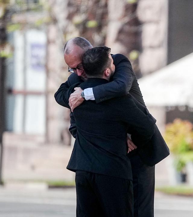 Bundeskanzler Friedrich Merz (CDU) und Wolodymyr Selenskyj, Präsident der Ukraine, umarmen sich beim Gedenken am Maidanplatz in Kiew.