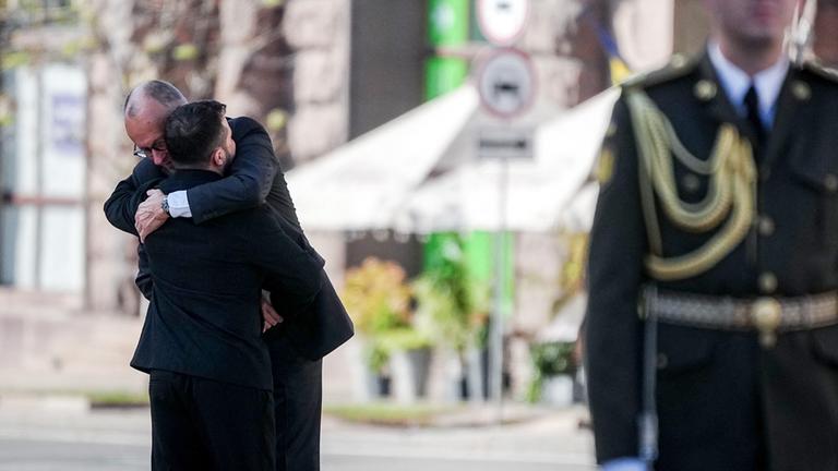 Bundeskanzler Friedrich Merz (CDU) und Wolodymyr Selenskyj, Präsident der Ukraine, umarmen sich beim Gedenken am Maidanplatz in Kiew.
