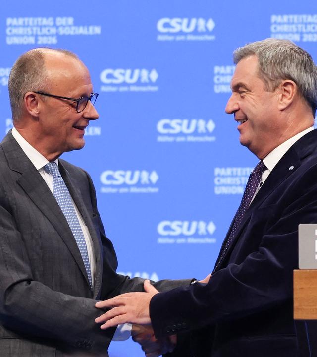 Handschlag von Merz und Söder auf der Bühne des Parteitags