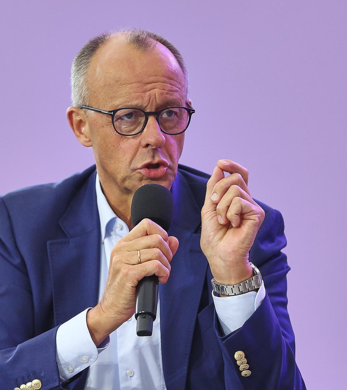 Bundeskanzler Merz, wie er in ein Mikrofon spricht