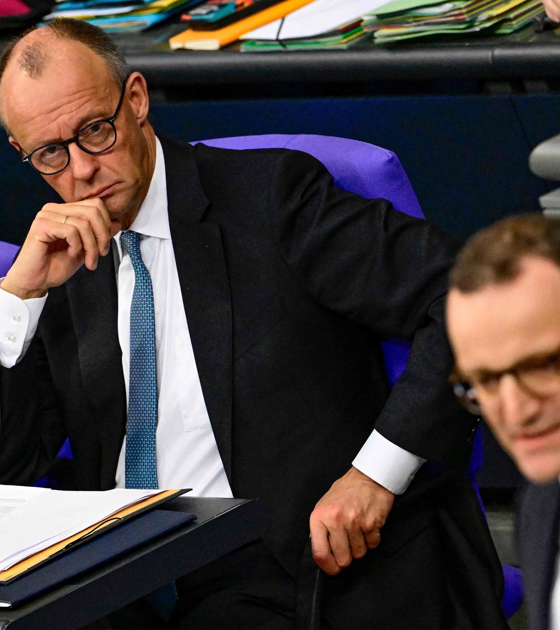 Der deutsche Bundeskanzler Friedrich Merz (links) blickt hinüber zu Jens Spahn, dem Fraktionsvorsitzenden der CDU, während einer Generaldebatte über den Haushalt des Bundeskanzleramts im Bundestag, dem Unterhaus des deutschen Parlaments, am 26. 11. 2025 in Berlin. 