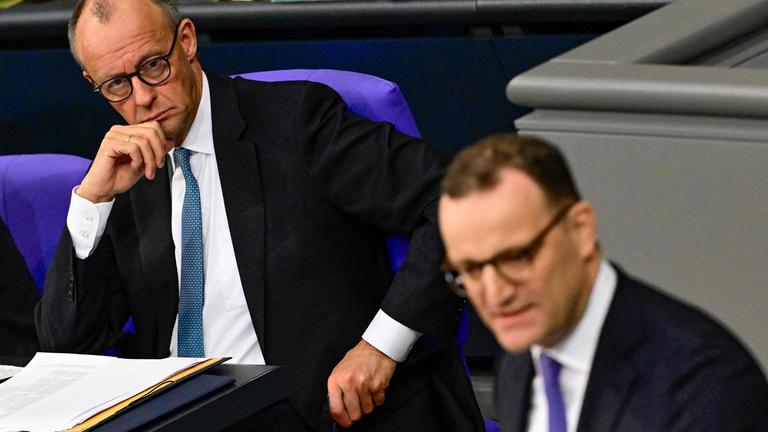 Der deutsche Bundeskanzler Friedrich Merz (links) blickt hinüber zu Jens Spahn, dem Fraktionsvorsitzenden der CDU, während einer Generaldebatte über den Haushalt des Bundeskanzleramts im Bundestag, dem Unterhaus des deutschen Parlaments, am 26. 11. 2025 in Berlin. 