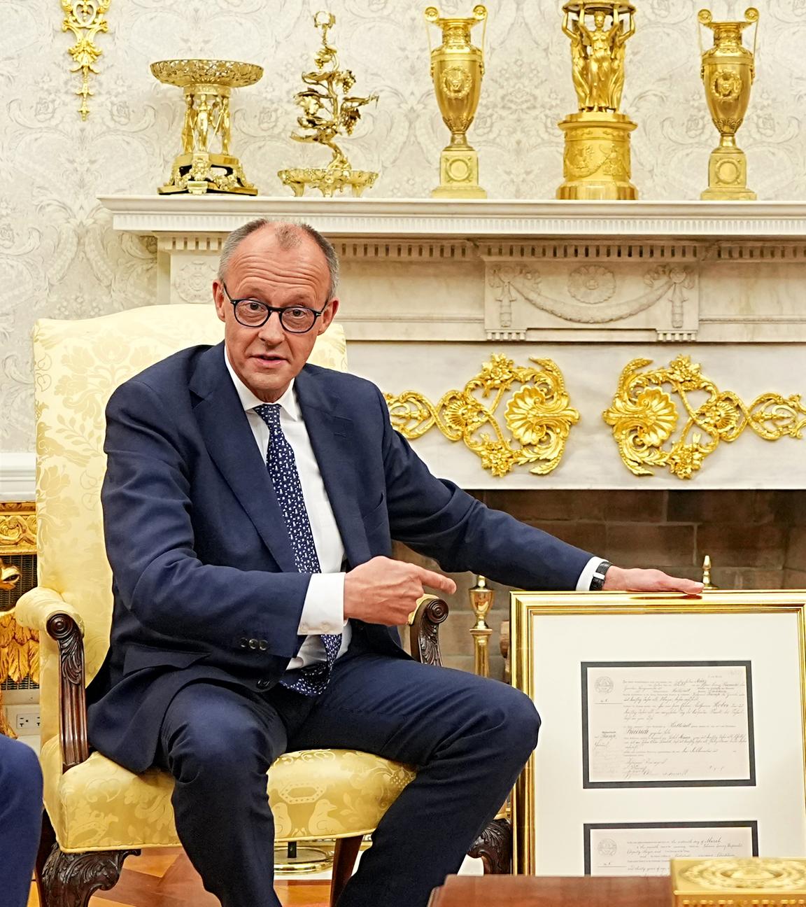 Bundeskanzler Merz und US-Präsident Trump sind vor dem Weißen Haus abgebildet.