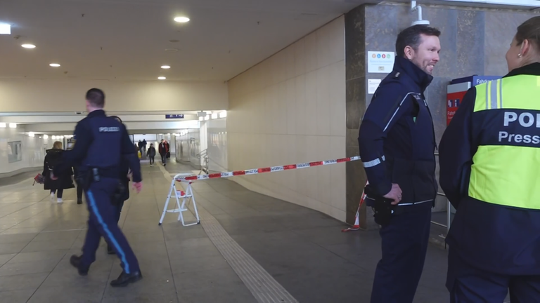 Drei Polizisten in einer Unterführung am Hauptbahnhof Würzburg. Ein Absperrband ist an einer Tretleiter befestigt.