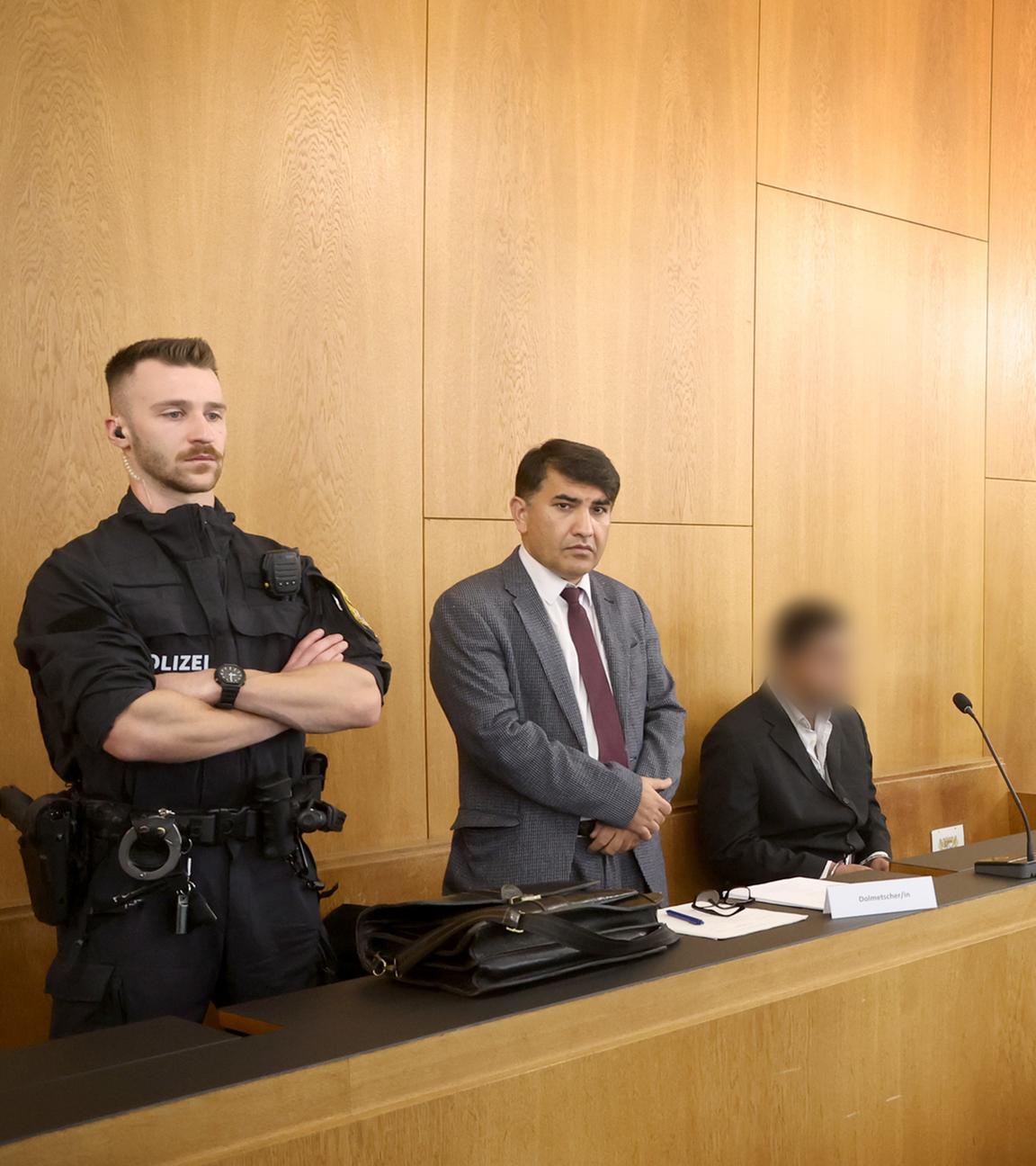 Ein Beschuldigter (3.v.l) sitzt im Gerichtssaal des Landgerichtes neben einem Dolmetscher (2.v.l) hinter seinem Anwalt Jürgen Vongries (r). 