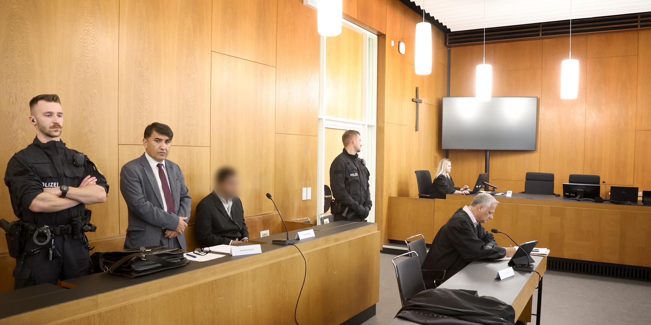 Ein Beschuldigter (3.v.l) sitzt im Gerichtssaal des Landgerichtes neben einem Dolmetscher (2.v.l) hinter seinem Anwalt Jürgen Vongries (r). 