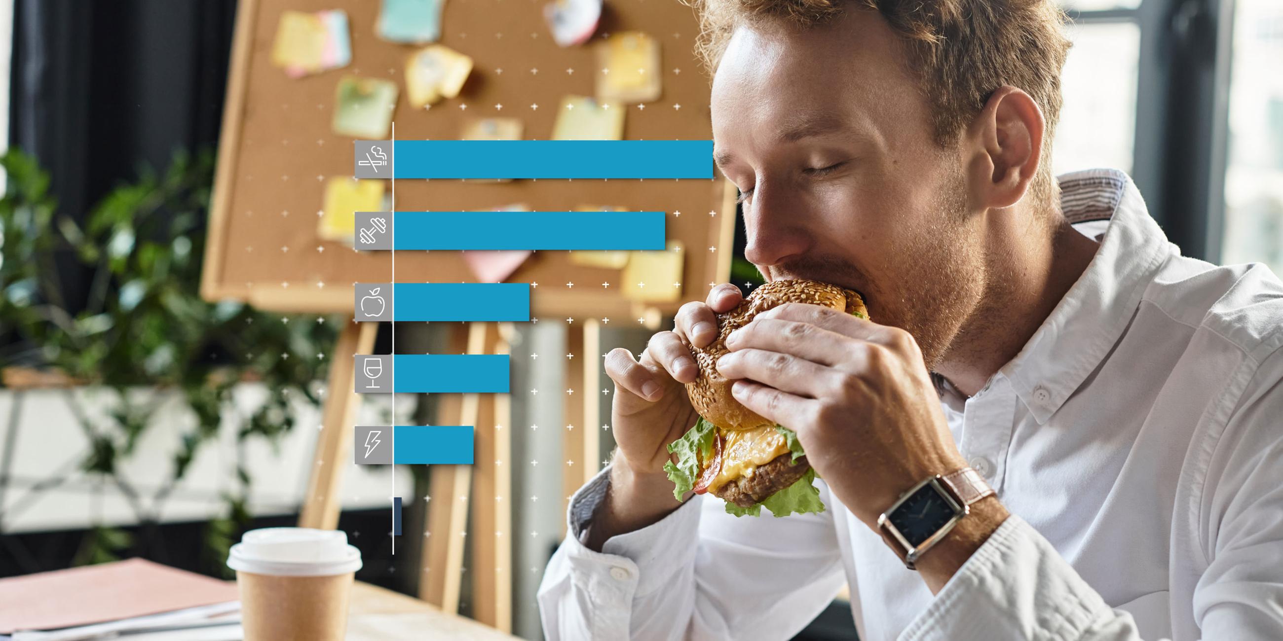 Ein Mann isst einen Hamburger im Büro.